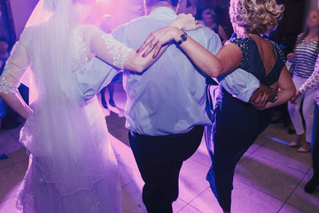 bride and groom having fun and dancing at wedding reception. holiday celebrations.  people dance at...