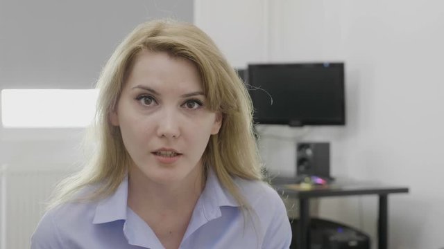 Young blonde office woman at work saying omg oh my God reaction with astonished face and opened mouth