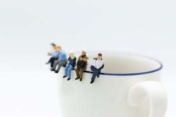 Miniature people : Business team sitting on cup of coffee and having a coffee break. Image use for business concept.
