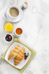 Breakfast served with croissants, coffee, orange juice and berries.