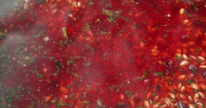 Close video of farro with beets and spinach and seasonings simmering in boiling water.