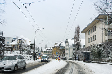 A snow track on the street along the houses.