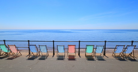 Row of empty deck chairs on the beach in Devon