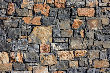 large wall of natural granite stones of different size and color, gray texture on a summer day, multi-colored granite natural stone, pieces of stone, splinters, texture pattern, stone wall, masonry