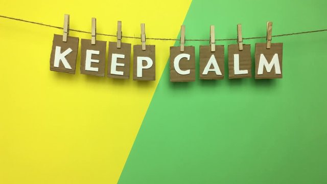 Frase &ldquo;keep calm&rdquo; colgando de una cuerda con pinzas.