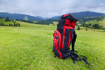 Travel backpack on the mountain  landscape view background. Traveler items. Vacation. Travel accessories. Holiday. Long weekend Day off. Travelling stuff