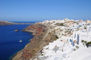 Fototapeta na wymiar Famous stunning view of white architectures and colors above the volcanic caldera in the village of Oia in Santorini island, Greece