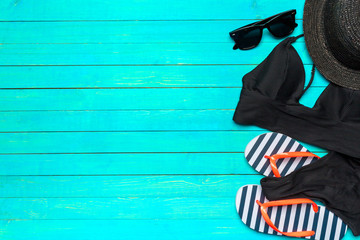 Composition with swimsuit on color wooden background