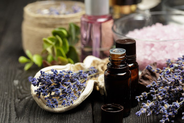Fototapeta na wymiar Aromatic composition of lavender, herbs, cosmetics and salt on a dark table top