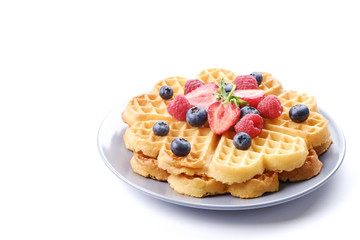 Festive breakfast composition with homemade waffles and variety of different summer berries and...