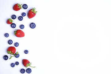 Bunch of fresh organic mixed berries, blueberry & strawberry in seamless pattern, white background. Clean eating concept. Healthy vegan snack, raw food diet. Close up, copy space, top view, flat lay.