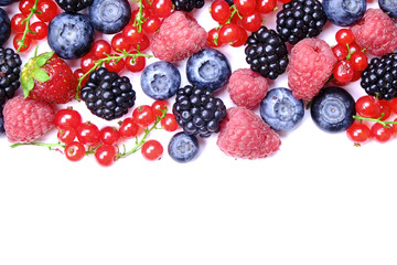 Bunch of mixed berries in harvest pile on white background. Colorful composition with fresh organic strawberry, blueberry, blackberry & redcurrant. Clean eating concept. Close up, copy space, top view