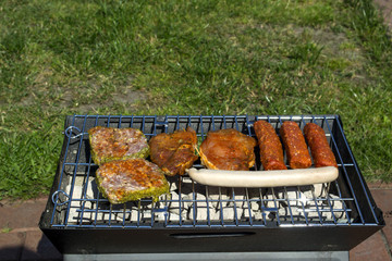 The sausages and meat on grill. Summer picnic outdoor.