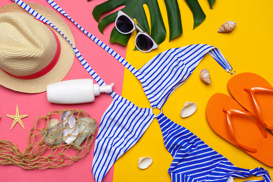 Beachwear and accessories on a pink and yellow background