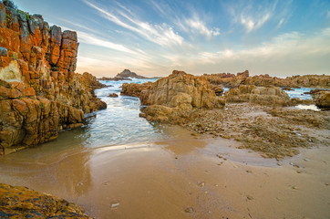 Knysna heads coast rocks, Indian Ocean waves through the rocks at sunset, Garden Route, South Africa