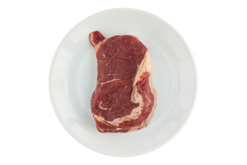 A raw piece of meat (ripe steak) on a white plate on an isolated background