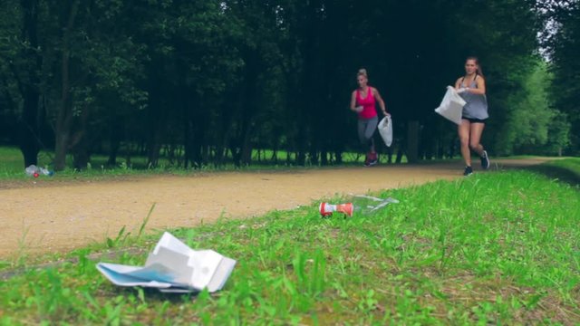 Girl crouching with bag picking up trash doing plogging