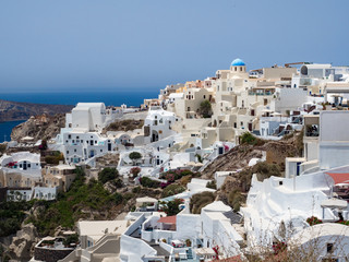 Naklejka premium Beautiful Oia town, Santorini island, Greece: Panoramic view. Traditional and famous white houses and churches with blue domes over the Caldera, Aegean sea.