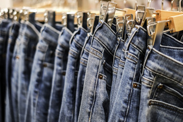 Row of hanged blue jeans pants in shop