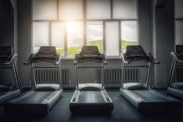 The interior of an empty gym with view of the picturesque mountains. Treadmill. The concept of a healthy lifestyle. Diet and fat burning. Sport and beauty.