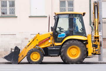 the yellow bulldozer stands at the old building