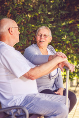 senior couple sitting on a park bench.