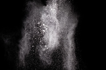 Bizarre forms of  white powder explosion cloud against dark background. Launched white particle splash on black background