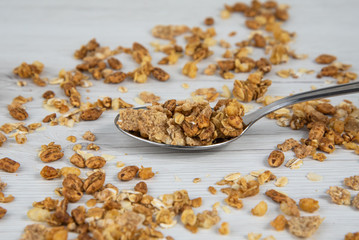 Spoon full of granola on white wood table
