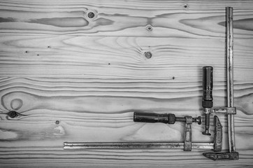 Old carpentry clamps on a wooden table.