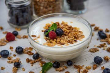 Jar full with granola, yogurt and fresh berries, close-up, selective focus