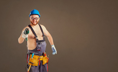 The fat funny man builder with a drill on a background for text.
