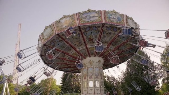 Kids ride on carousel in amusement park.