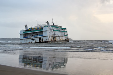 Marine vessel, an offshore casino, that run aground near Miramer beach in Goa, India, waiting for...