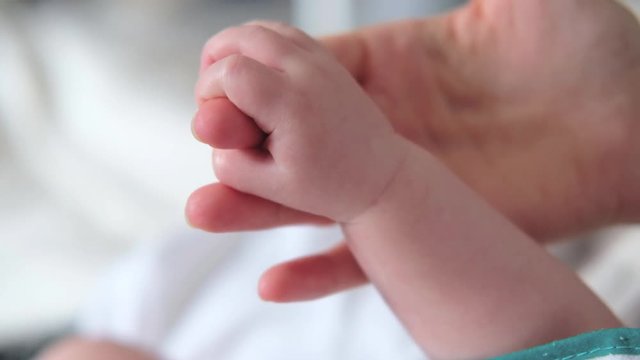 Mother holding baby hand. Newborn baby hand in mother hands. 4K UHD Slow motion