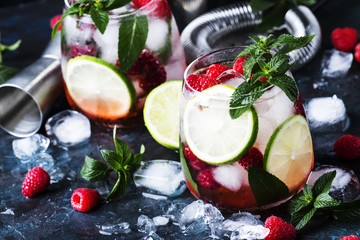Summer cool alcoholic cocktail raspberry mojito cocktail with lime, rum, mint and ice. Bar tools,...