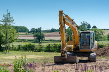 Fototapeta na wymiar yellow digger with bucket in the countryside