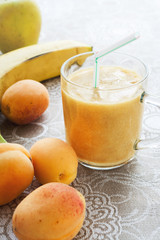 Close-up apricots, Apple and banana and fruit smoothie in glass on linen tablecloth.