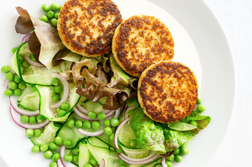 salad of pea, cucumber, and onion with cod cutlets in lettuce leafs served with mayonnaise sauce 