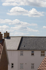 Suburban housing. Modern white house building with slate roof tiles.