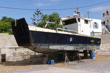 A fishing ship boat on the lift in a parking lot in the island of Patmos, Greece