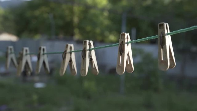 Clothespins hang on a rope on open air summer house