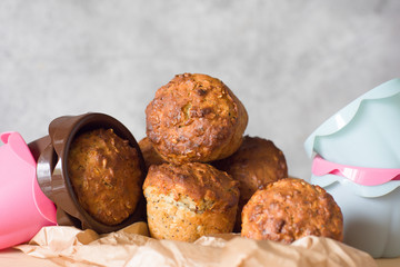 Healthy muffins from whole-grain cereals and oat flakes with poppy close-up against a background of baking molds and a wooden board.