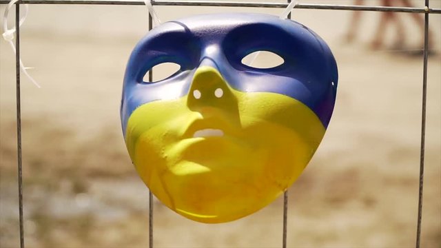 blue-yellow mask hanging on the fence and staggering in the wind