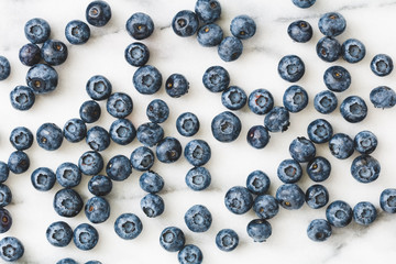 Fresh ripe blueberries over white marble. Food background. The concept of healthy eating and lifestyle.