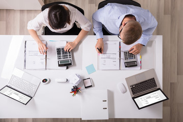 Two Businesspeople Calculating Invoice