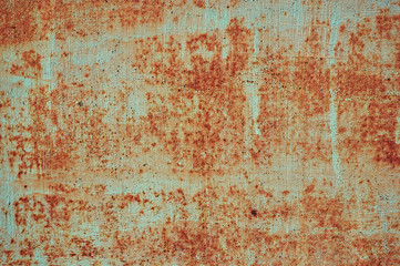 An old painted sheet of iron covered with rust. Abstract background.