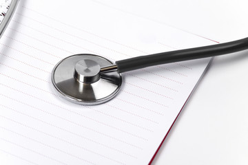 Medical concept with stethoscope on doctors notepad