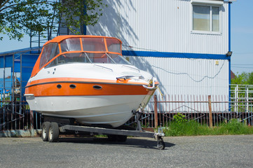 Boat on stand on the shore, maintenance and parking place boat, marine industrial