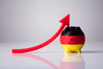 Close-up Of Piggybank Painted With German Flag And Red Arrow