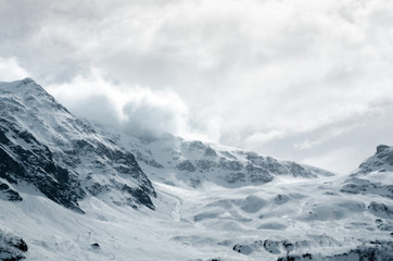 Fototapeta na wymiar Gigantic blizzard snow storm clouds casting over the mountain peaks
